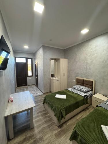 a bedroom with two beds and a table in it at Hotel Hovit in Bagratashen