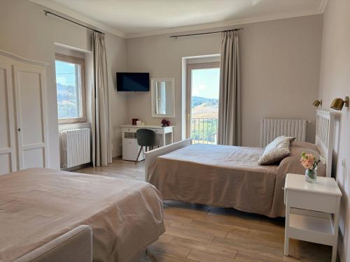 a hotel room with two beds and a window at Agriturismo Villa Luisa in Apice