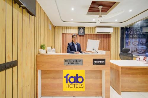 a woman is sitting at a reception desk at FabHotel Vaishnavi Classic in Secunderabad
