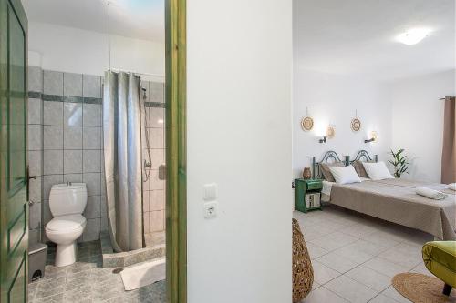 a bathroom with a toilet and a bed in a room at Pavlos Maria studios in Skiathos