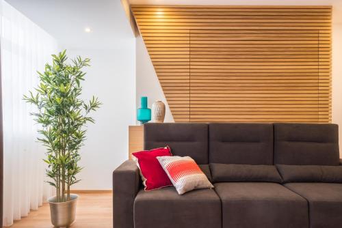 a brown couch in a living room with a plant at Almada Domus in Porto