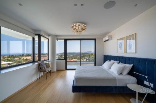 a bedroom with a large bed and large windows at Aurora Residence by A&D Properties in Neos Voutzas