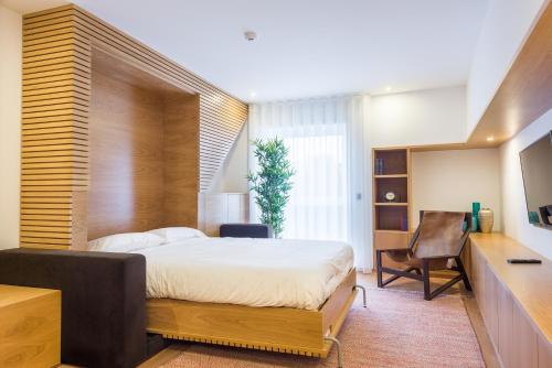 a bedroom with a bed and a desk and a chair at Almada Domus in Porto