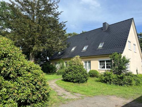 a yellow house with a black roof at Natur & Ruhe in Worpswede