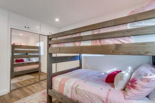 a bedroom with two bunk beds and a mirror at Beautiful Remodel 3 Bedroom 2 bathroom Home with Pool & Jacuzzi in Fullerton