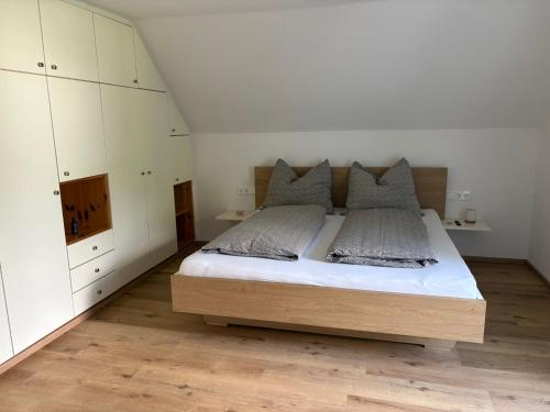 a bedroom with a large bed with white cabinets at Ferienhaus Meisterl in Sankt Marein bei Neumarkt