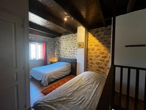 a small bedroom with two beds and a window at Gîte authentique avec piscine en Aveyron in Morlhon-le-Haut
