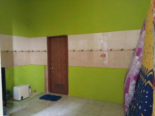 a room with green and white walls and a door at Priv garut in Garut
