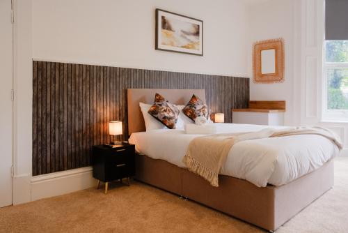 a bedroom with a large bed and a mirror at Stockton Suites in Stockton-on-Tees