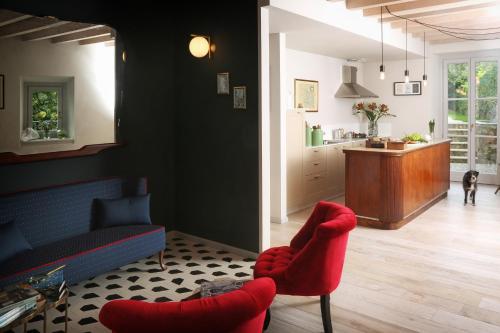 a living room with red chairs and a kitchen at Dos del Sul in Roe