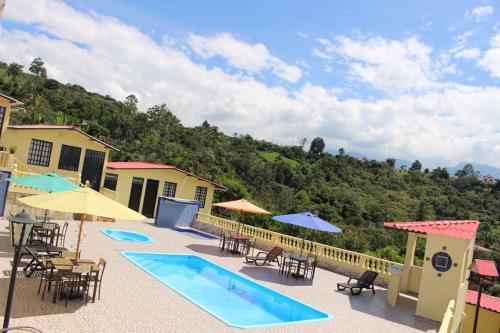 un resort con piscina, tavoli e sedie di Casa Campestre Villa Esperanza a Silvania