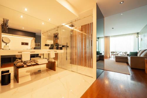 a bathroom with a glass shower and a living room at Quinta de Silvalde in Santo Tirso