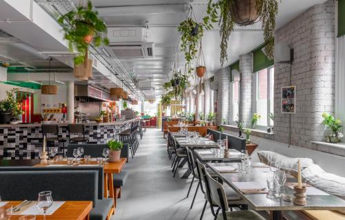 a restaurant with tables and chairs and plants at Whitworth Locke in Manchester