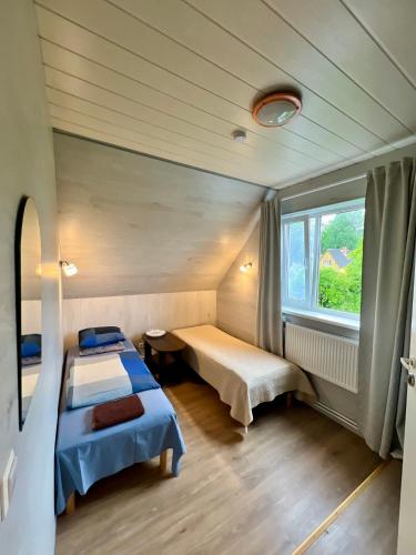 a room with two beds and a window at Liiva Guest Accommodation,free parking in Tartu