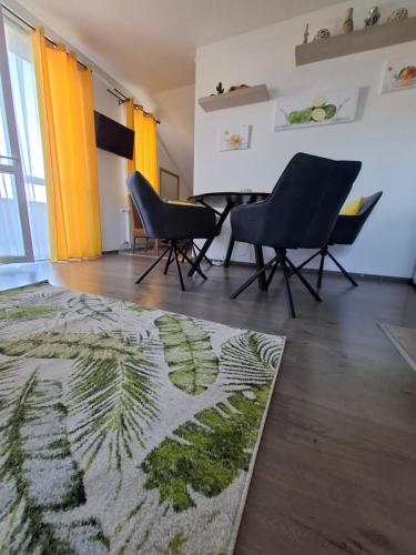 a living room with two chairs and a rug at Lemon Garden Villapark in Bükfürdő
