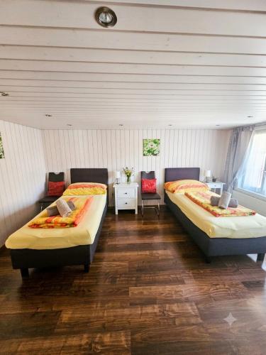 a bedroom with two beds and a table at Ferien im Paradies - Zwischen Bergen & Seen in Brienzwiler
