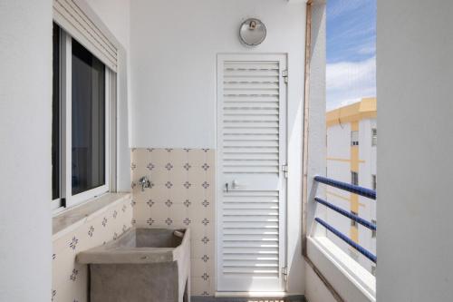 a bathroom with a sink and a window at Rei Apartment in Quarteira