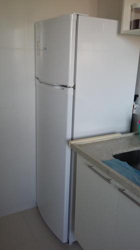 a white refrigerator in a kitchen with a counter at Condado Aldeia dos Reis 205 e 213 in Mangaratiba