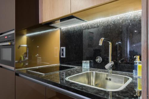 a kitchen with a sink and a counter top at Almada Domus in Porto