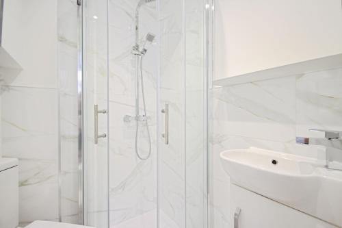 a white bathroom with a shower and a sink at APod in Coventry