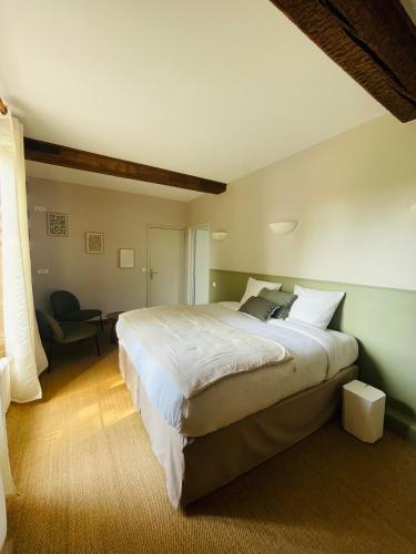 a bedroom with a large bed and a chair at Maison Nolette - Chambres & Table d'hôtes in Noyelles-sur-Mer