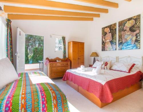 a bedroom with two beds and a painting on the wall at Villa SOFIA - Costa Blanca in Benissa