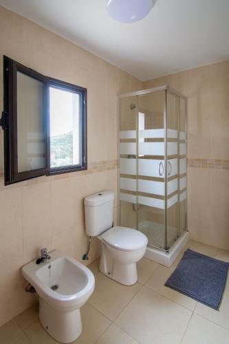 a bathroom with a toilet and a shower and a sink at Casa de Los Maestros in Bicorp