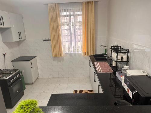a kitchen with black counter tops and a window at Nalim bliss garden in Ruiru