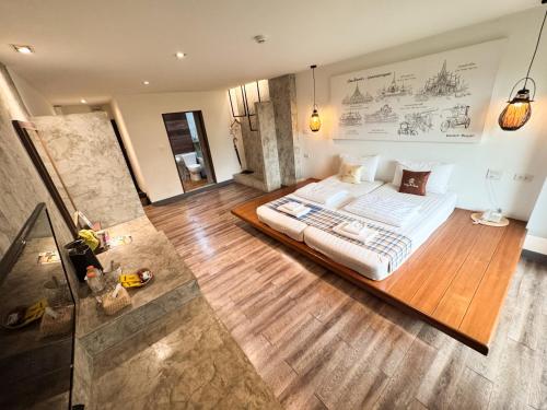 a bedroom with a large bed on a wooden floor at Boutique Poo-Yai Lee in Bangkok