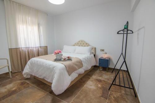 a bedroom with a large bed and a tripod at El Prado, 2 in El Mármol