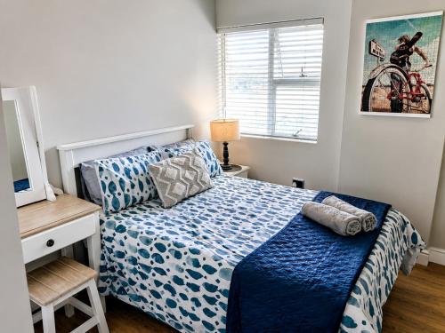 a bedroom with a bed with a blue comforter at 501 Beach Club in Mossel Bay