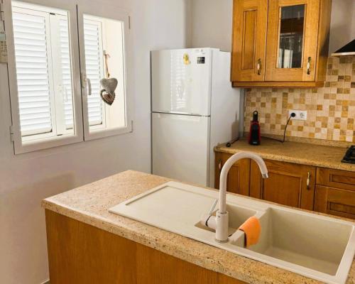 a kitchen with a sink and a white refrigerator at Villa SOFIA - Costa Blanca in Benissa