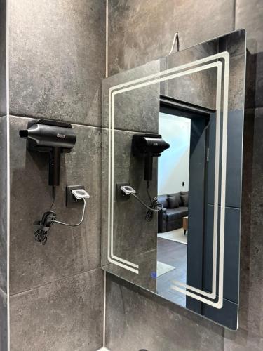 a mirror on a bathroom wall with a mirror at La Luna Apartman in Bečej