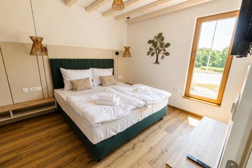 a bedroom with a large bed with a large window at Glamping resort Dolenjc in Novo Mesto