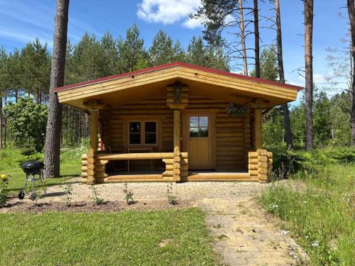 a small log cabin with a red roof at Jäneda Safari Puhkemajad in Kõrveküla
