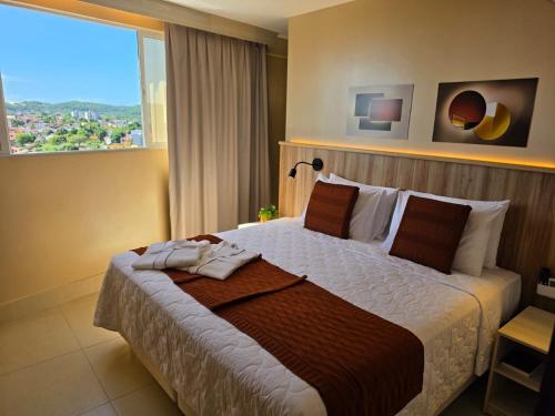 a bedroom with a large bed with a large window at Bali Mar Hotel in Natal
