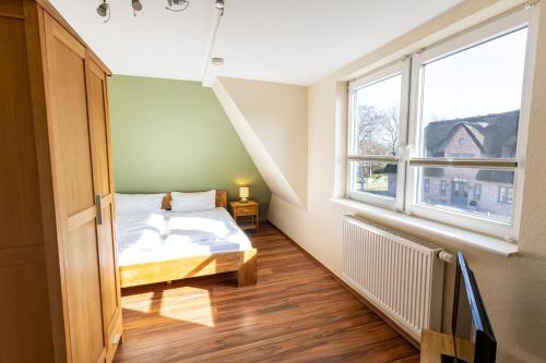 a bedroom with a bed and a window at Appartement Tümmelkoje in Sankt Peter-Ording