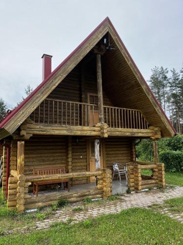 a log cabin with a porch and a bench at Jäneda Safari Puhkemajad in Kõrveküla