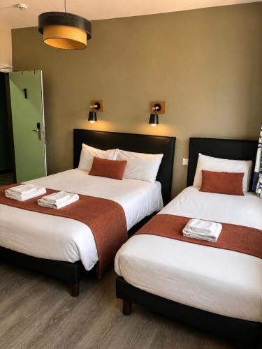 two beds in a hotel room with two at L'Aiguille Creuse in Étretat
