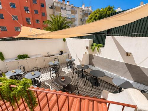 a patio with tables and chairs on a balcony at The Twenties by GuestReady in Lisbon