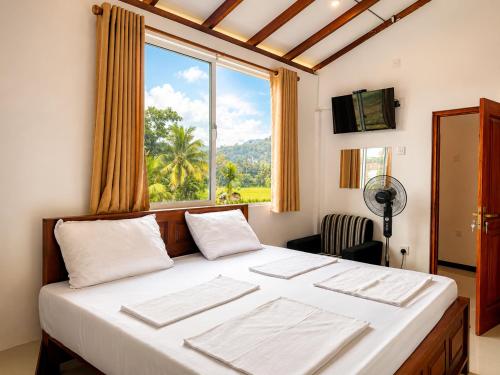 a bedroom with a large bed with a window at Namali Guest House in Badulla