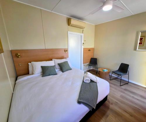 a bedroom with a large white bed with two pillows at Murrurundi Motel - CITY CENTRE in Murrurundi
