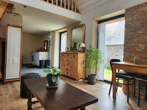 a living room with a table and a mirror at Ti an Avel, petite maison indépendante avec jardin à 5 minutes à pied de la mer in Plougrescant