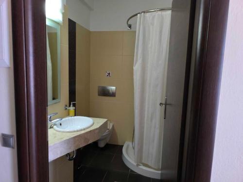 a bathroom with a sink and a shower curtain at Golden Rose Suites in Kolymvari