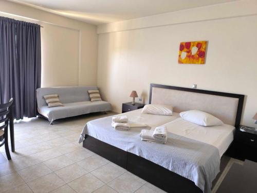 a bedroom with a large bed and a couch at Golden Rose Suites in Kolymvari