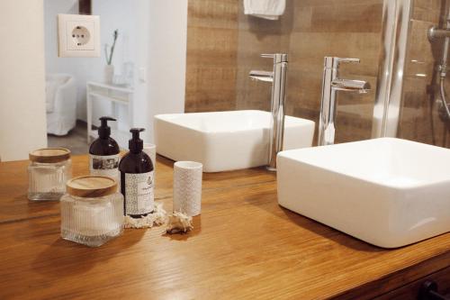 a bathroom counter with a sink and bottles of wine at Vila Vale Guest House - Surf & Yoga in Charneca