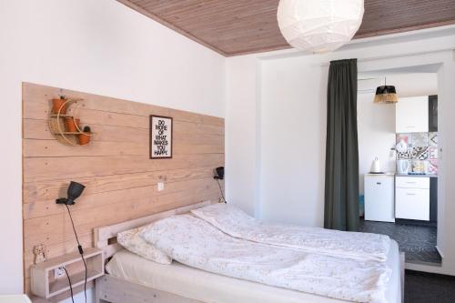 a bedroom with a bed with a wooden headboard at Studio apartment LoSt in Ogulin