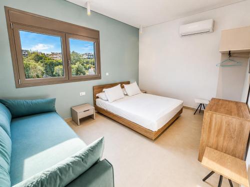 a bedroom with a bed and a couch and a window at B Cozy Apartments in Limenaria