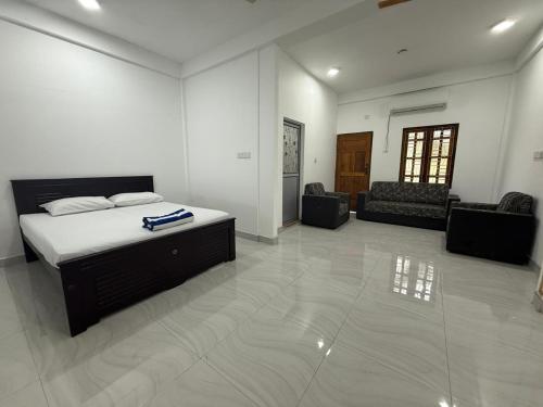 a bedroom with a bed and a living room at Jaffna Gateway Hotel and Restaurant in Kanakarayankulam