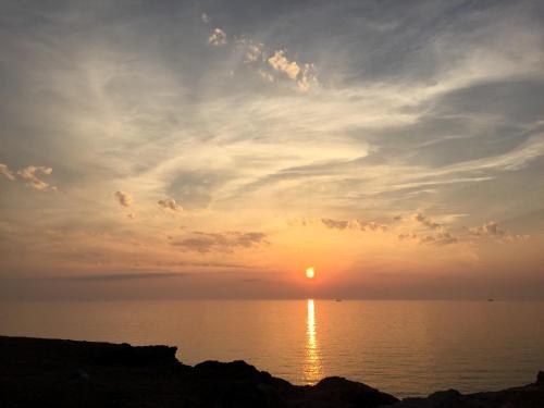 a sunset over the ocean with the sun in the sky at Room 86 in San Vito lo Capo